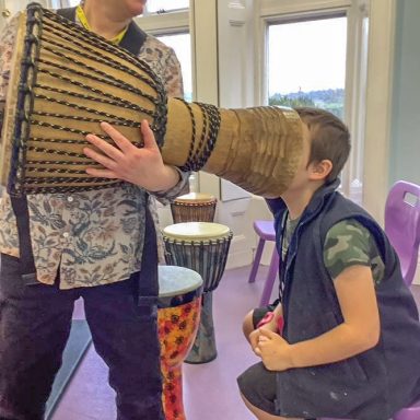 Boy with head inside a djembe drum