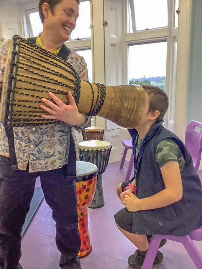 Boy with head inside a djembe drum